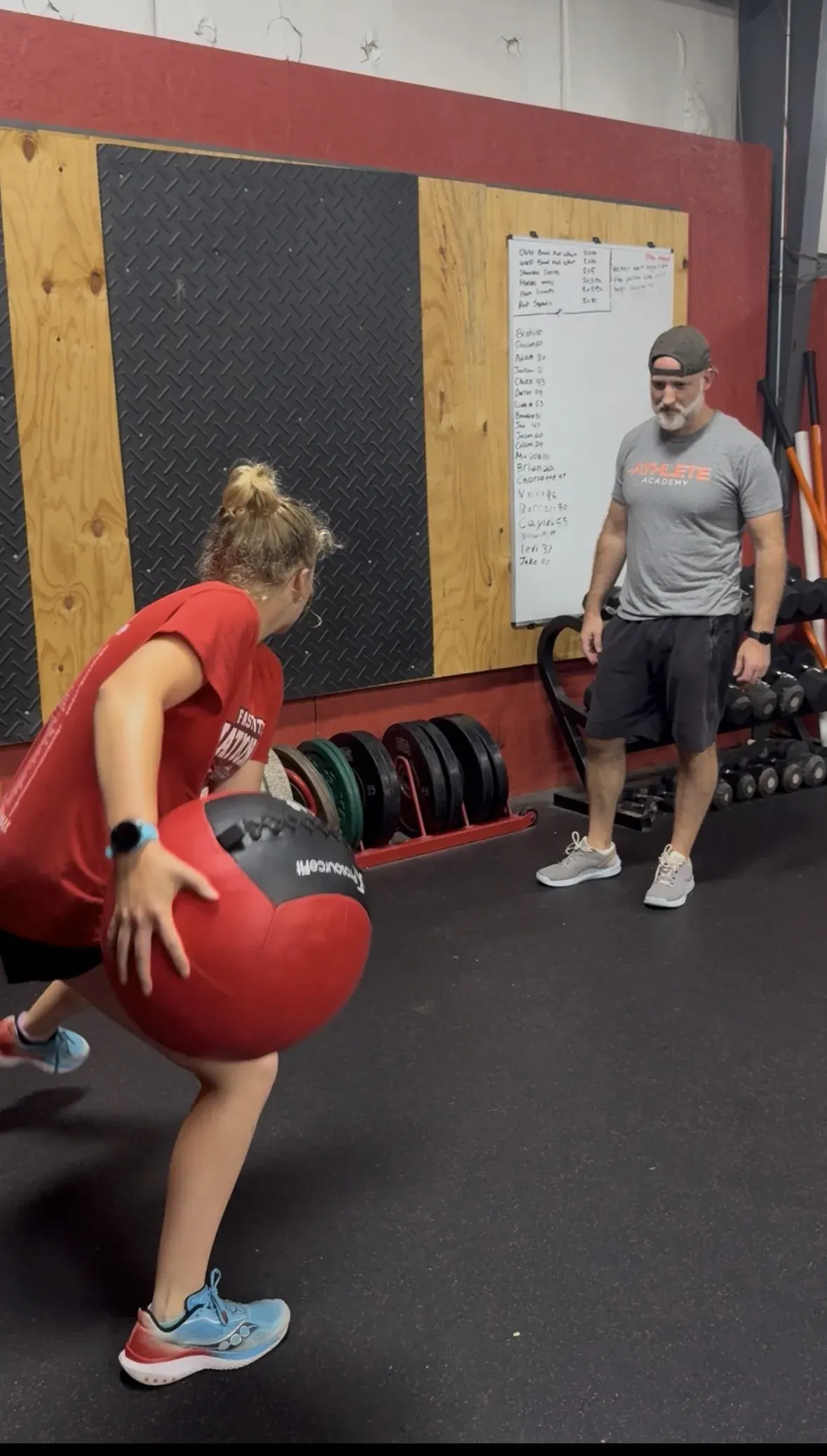 Coach Aaron coaching an athlete through a med ball throw